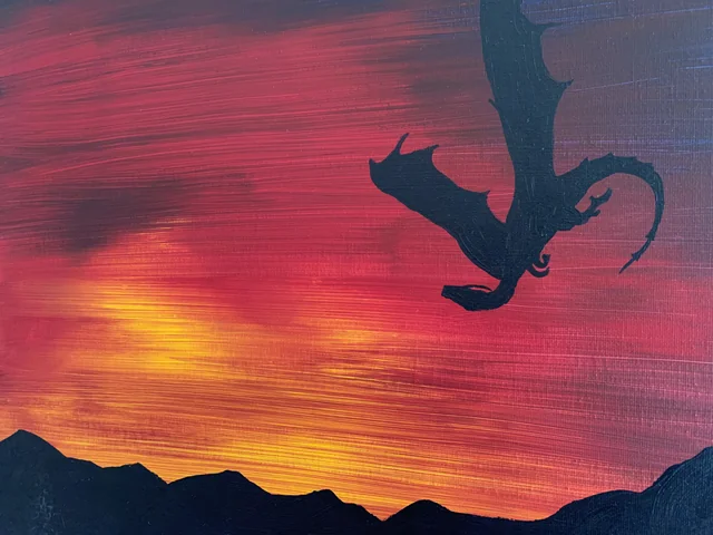 Flying dragon silhouetted against a red and golden sunset