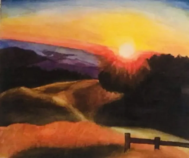 Sunset over rolling fields with a fence in the foreground
